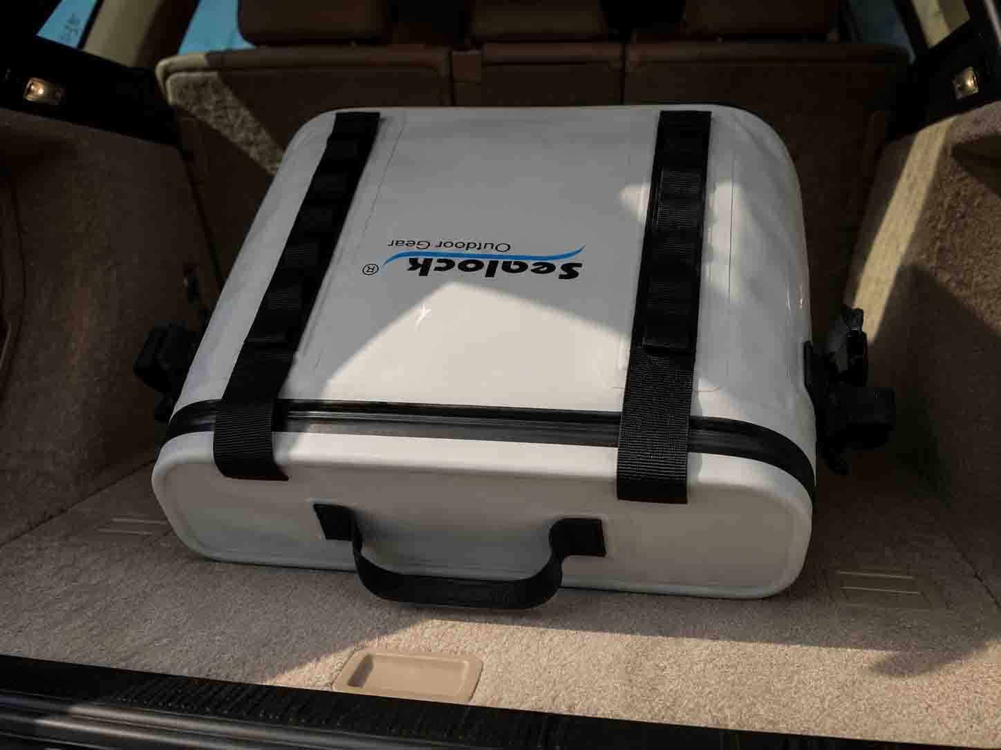 An inverted OEM soft cooler demonstrating 100% leak-proof performance with an airtight zipper in a car trunk.